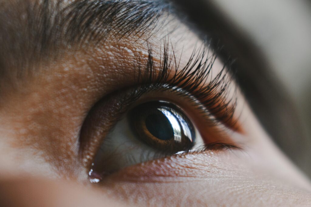 Macro shot of a human eye showcasing long eyelashes, iris detail, and reflection.